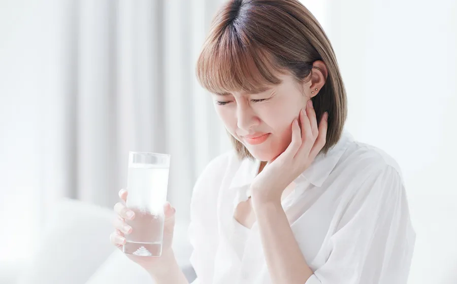 冷たい飲み物がしみる女性